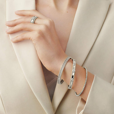 Model wearing silver Fleuron Paris Perlee Bangle - 18k gold plated with zircon, styled with matching ring and bracelets for a luxe look.