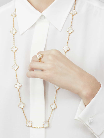 Model wearing Fleuron Paris Clover Leaf Gold Necklace in white mother-of-pearl with matching ring, 925 silver and 18k gold plated chain.