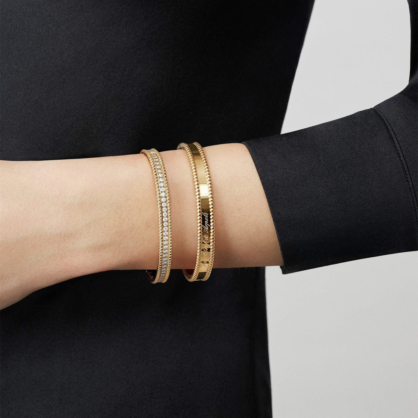 Model wearing Fleuron Paris Perlee Bangle - 18k gold plated with zircon, paired with matching bangles for a chic, layered bracelet look.